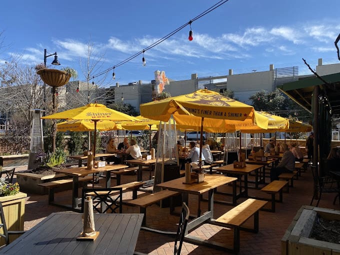 Dig into Texas barbecue on a lively patio shaded by bright yellow Shiner umbrellas and stocked with cold beer. (Courtesy)