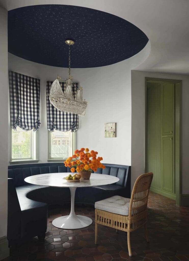 The breakfast-room banquette is custom made in Brentano leather from Pholio Co. Paul Ferrante chandelier.  (Photo by Douglas Friedman)