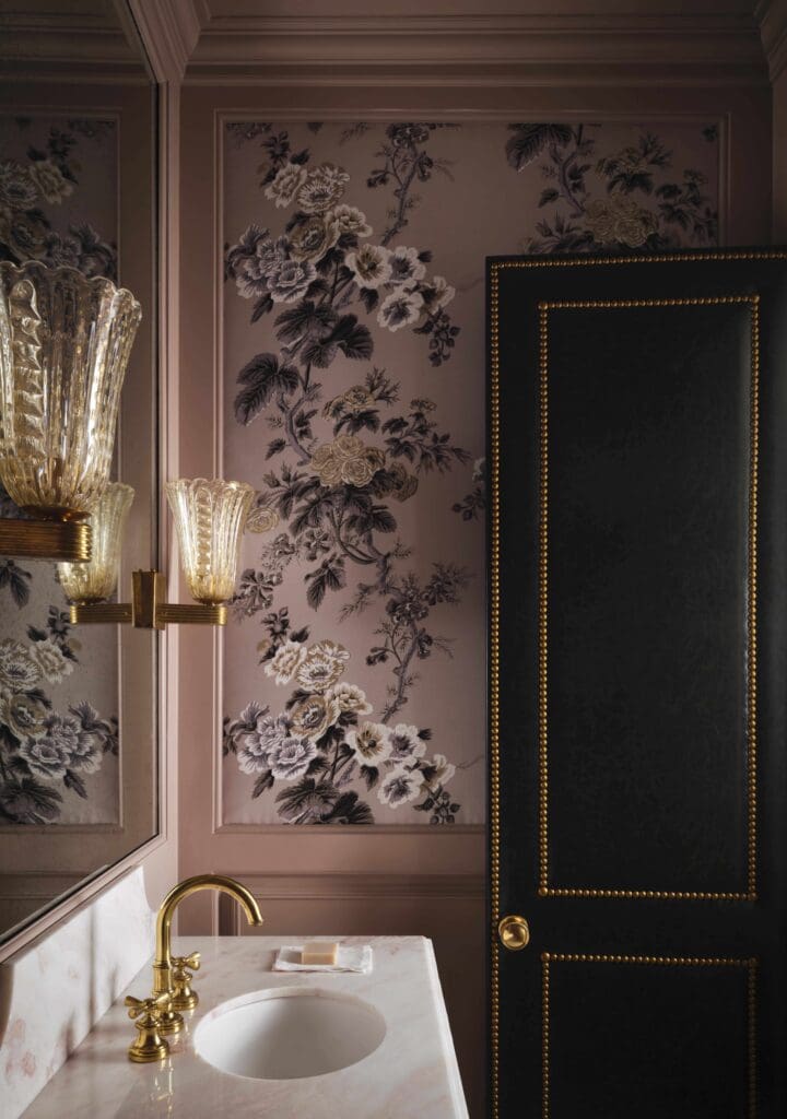 A powder bath wallpaper is Pyne Hollyhock by Schumacher. Custom door in Brentano leather from Pholio Co. Vintage Murano sconces.  (Photo by Douglas Friedman)