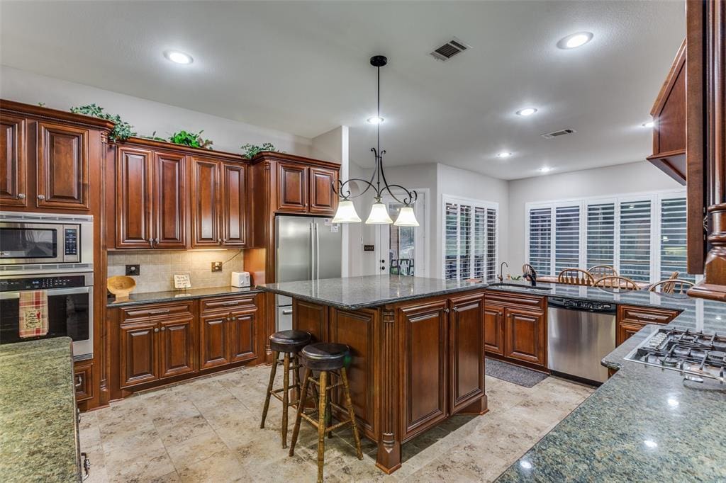Inside 100 Stone Canyon Circle, the layout is generous and open, with high ceilings, oversized windows, and fluid transitions between living, dining, and kitchen areas. 
