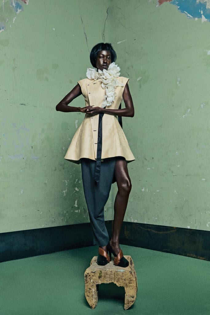 Louis Vuitton sleeveless asymmetric buttoned dress $7,900, one-leg pant $3,900, and Col Petales garland $2,390. (Photo by Bryan Flores)