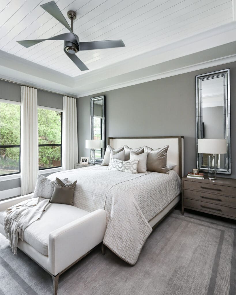 The primary bedroom features minimal window treatments, allowing full views of the backyard. (Photo by Charbonneau Interiors)