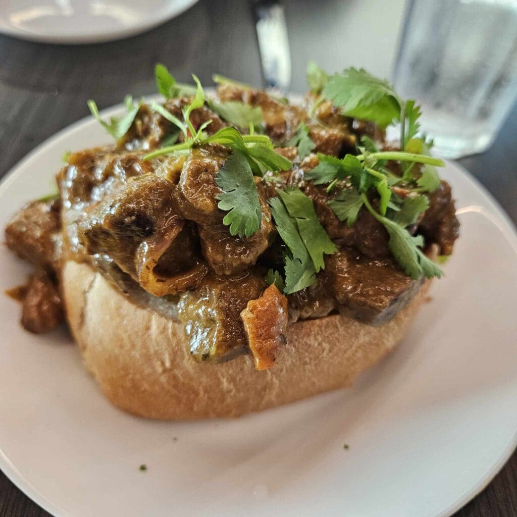 At Karino's, The Bunny Chow is a hearty South African stew served in a hollowed-out loaf of bread and packed with bold, comforting flavor. (Photo by Edward Brown)