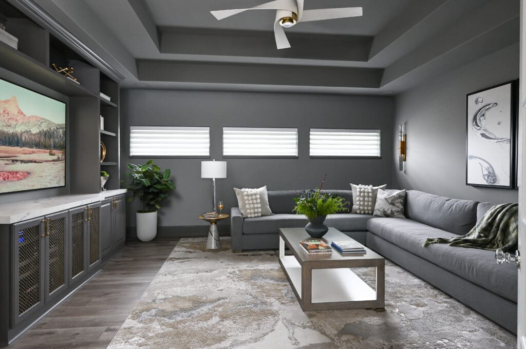 The cozy family room/media room features brass-toned screening on the built-ins. (Photo by Charbonneau Interiors)