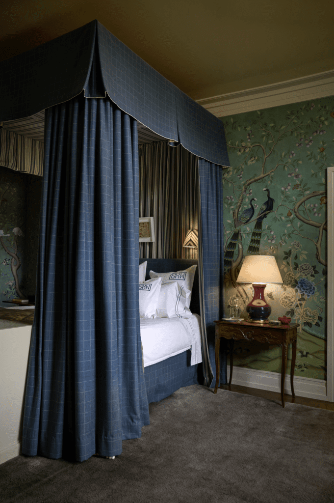The primary bedroom wallpaper is de Gournay. Canopy in Lee Jofa windowpane pattern fabric and 
Rose Tarlow stripe fabric. 
Christopher Spitzmiller lamp.  (Photo by Pär Bengtsson)