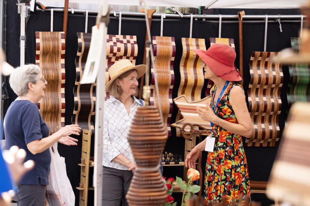 Art lovers connect inside one of the artist booths at The Woodlands Waterway Arts Festival. (Photo courtesy Mauricio Ramirez)