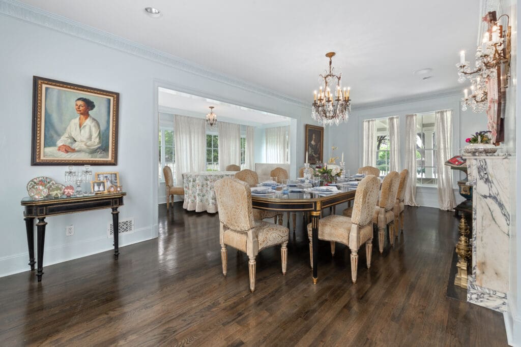 The formal dining room features crystal chandeliers, detailed trim, and a marble fireplace for refined entertaining.  (Photo by Freeze Media FW)