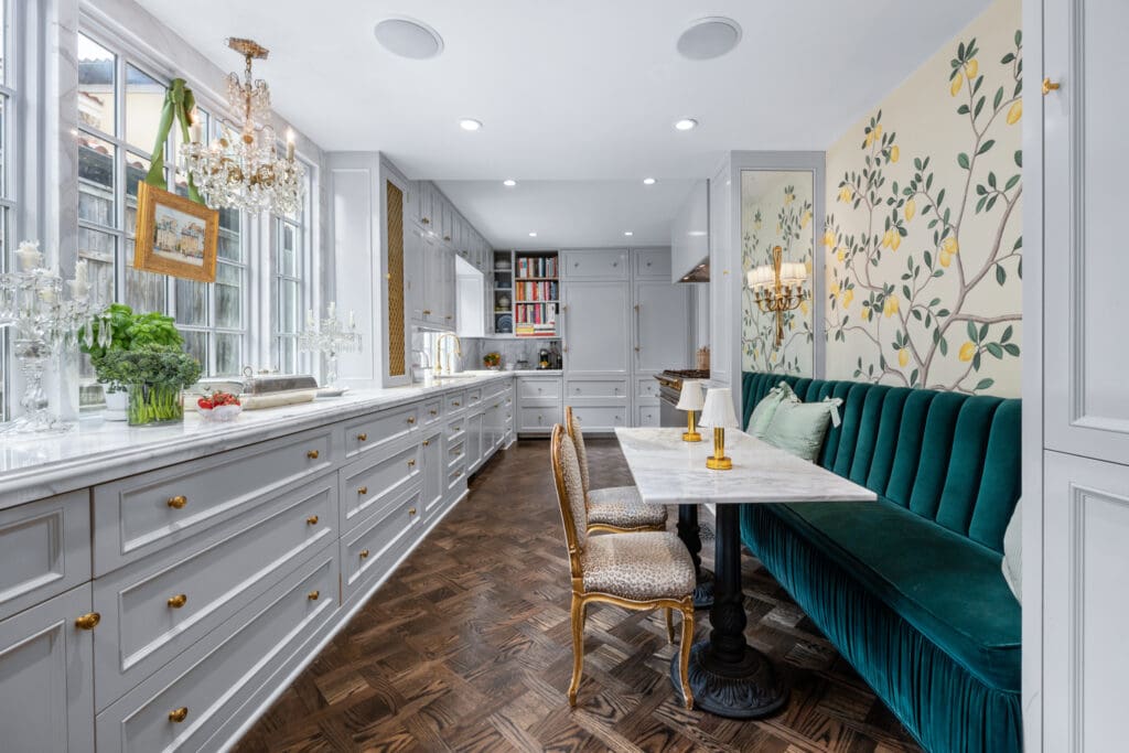 Custom cabinetry, marble countertops, and a velvet-lined banquette elevate the home's thoughtfully designed kitchen. (Photo by Freeze Media FW)