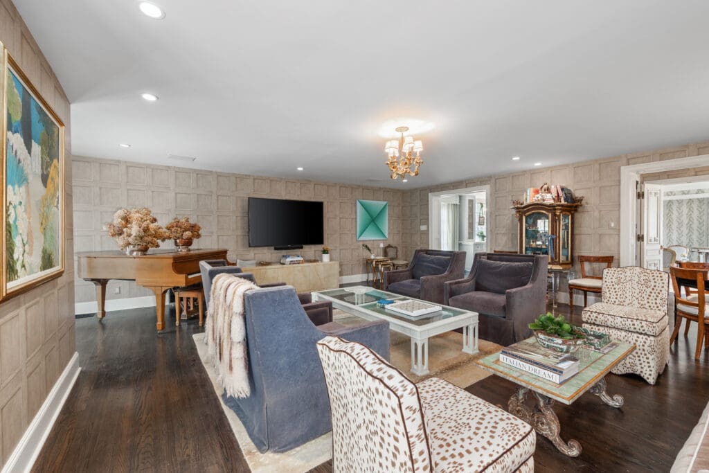 Paneled walls and rich wood floors bring warmth and sophistication to the expansive main living area.  (Photo by Freeze Media FW)