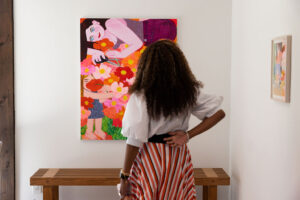 Annika Cail admires artwork by Madeline Donahue. (Photo by Kaitlin Saragusa Photography) (Photo by Kaitlin Saragusa Photography)