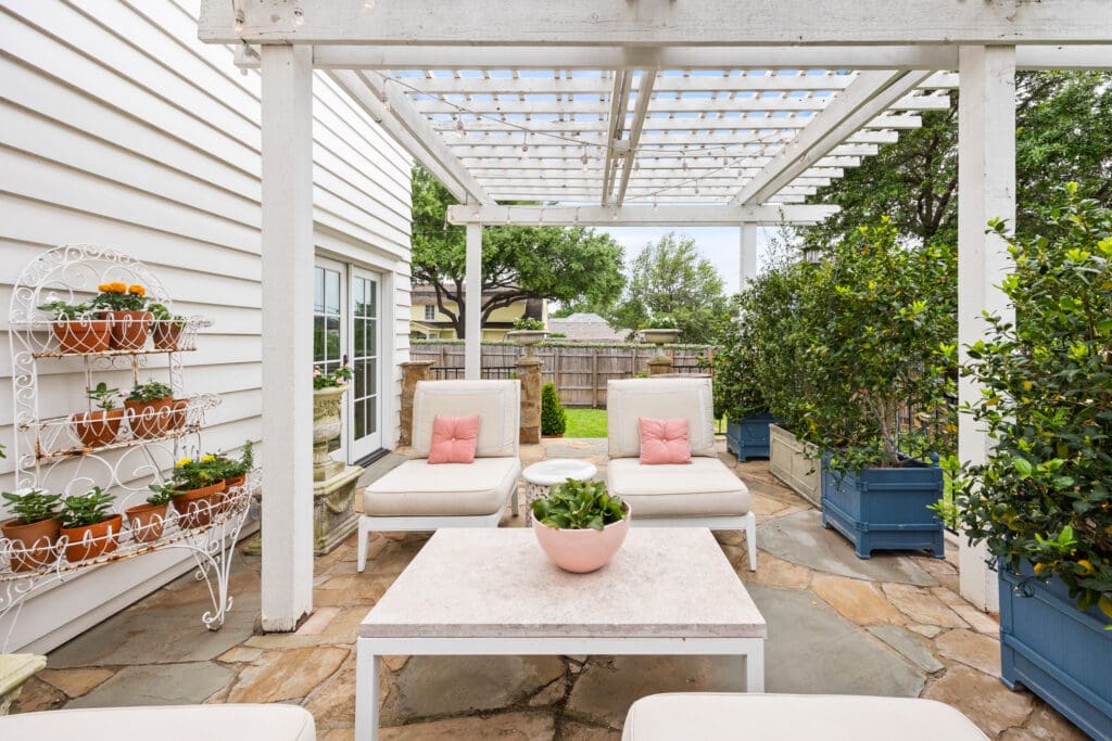 A vine-wrapped pergola and stone patio create a serene outdoor retreat perfect for lounging or entertaining. (Photo by Freeze Media FW)