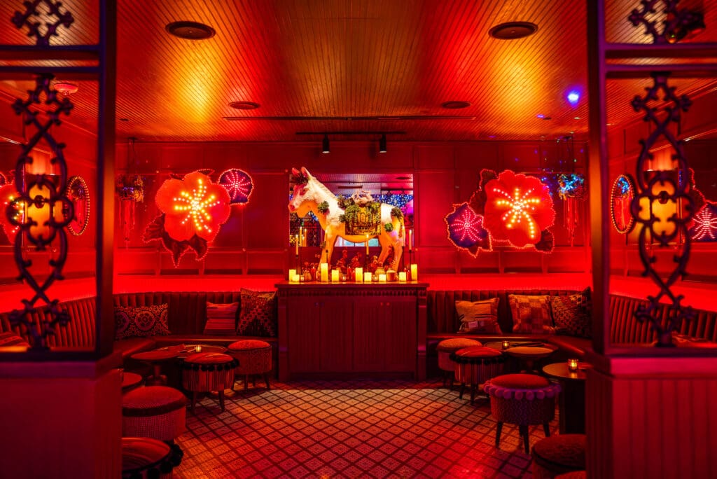 The Dallas location of Ghost Donkey features a life-sized donkey wearing parade florals, as well as neon lighting and multi-colored ceiling lights. (Courtesy)
