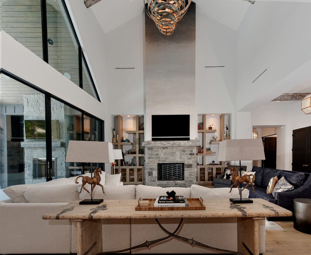 A vaulted ceiling in the living room shows a custom wine barrel light fixture.  The iron and glass doors allow access to the backyard.