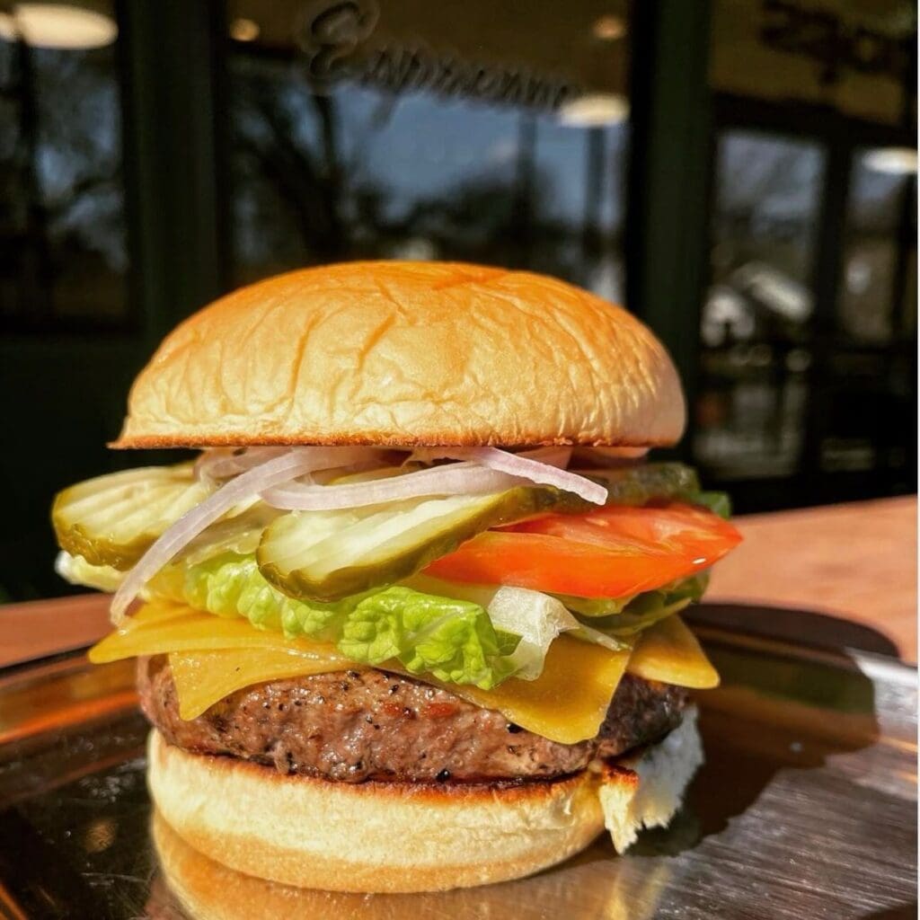 Roy Pope Grocery’s classic, no-frills burger hits all the right notes with a juicy patty, American cheese, and house Dijon mayo on a soft potato bun. (Courtesy)