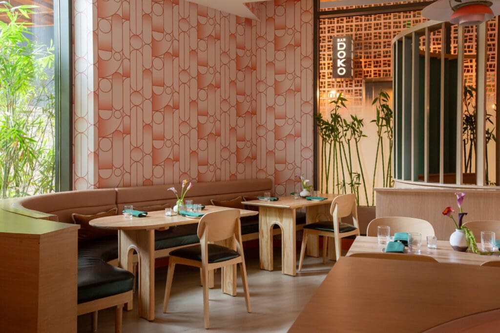 Doko's interiors have a cool mid-century vibe with light woods throughout, a coral and petal pink geometric patterned wallpaper, and soft, flattering lighting care of custom Louis Poulsen pendants.  (Photo by Photos by Studio Rivera)
