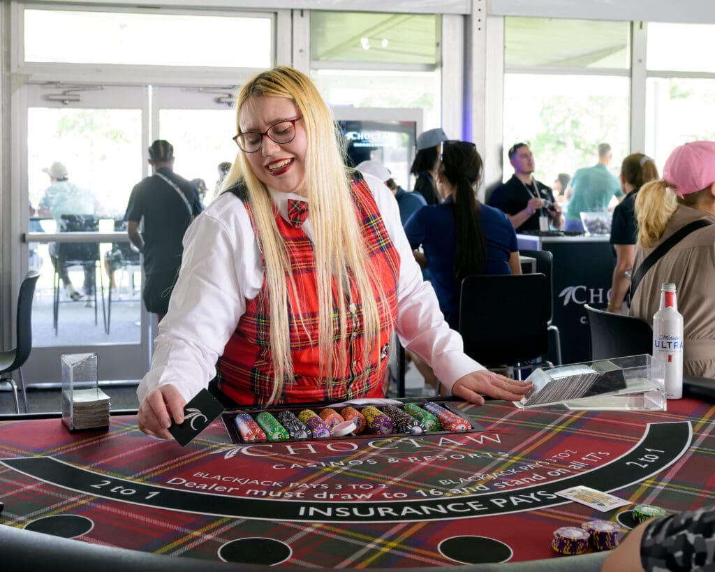 A Choctaw Club dealer in tartan plaid deals out blackjack hands as the party atmosphere peaks inside the new hospitality tent. (Photo by Walt Burns)