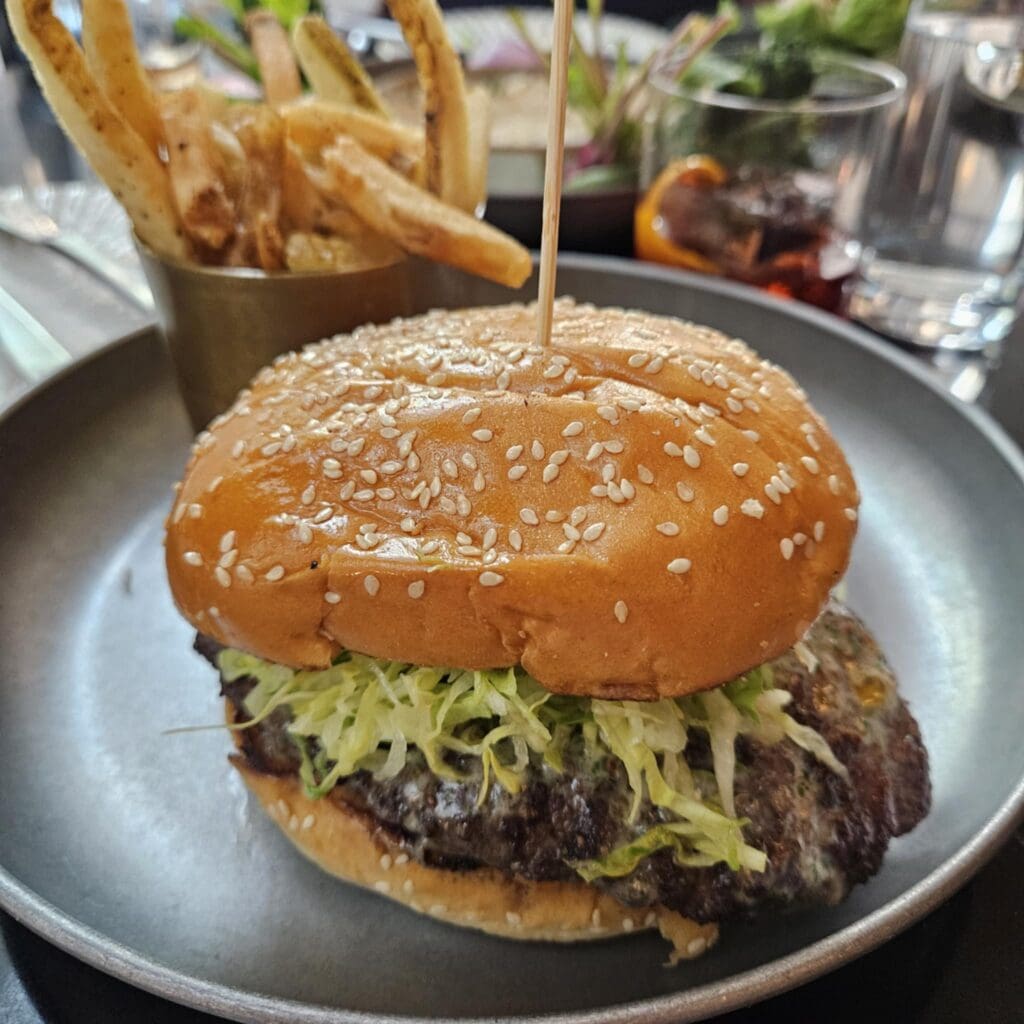 The Griddled Jalapeño-Onion Burger at Duchess brings bold flavor with a thick, seared patty, jalapeño relish, and a buttery cheese melt—all crafted by Chef Casey Thompson. (Photo by Edward Brown)