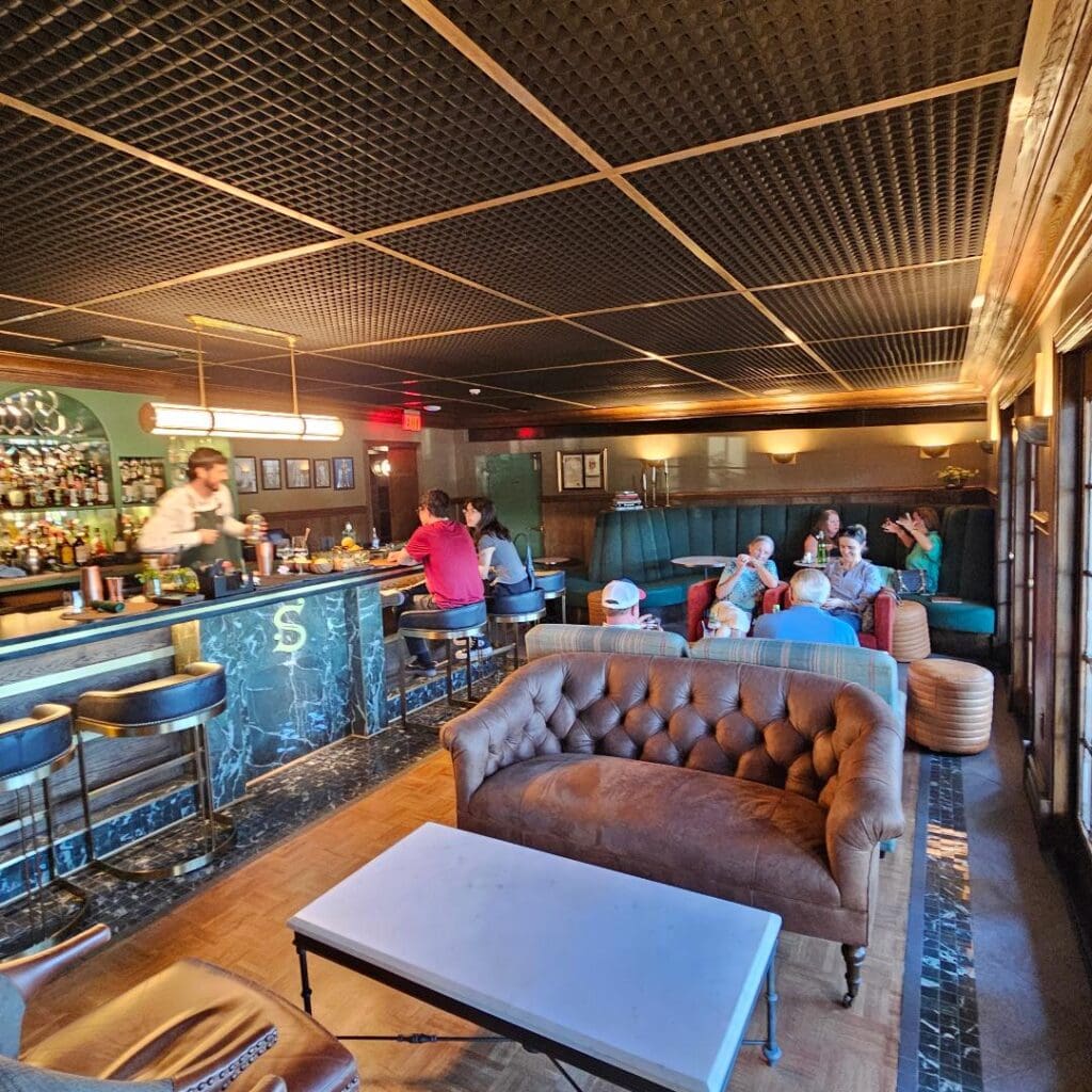 Inside at Stewart's, the single elongated dining room features a long central bar flanked by couches, including a plush velvet banquette along the back wall.  (Photo by Edward Brown )