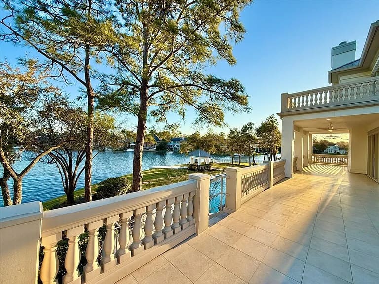 A large second story balcony has views of the pool and Lake Woodlands.