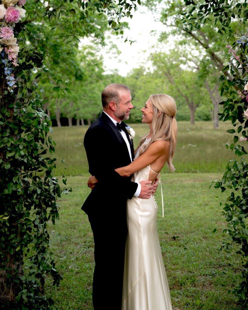 Madeline McCrann and Toby Potter share a quiet moment beneath their floral arch at Chandelier Grove. (Photo by Jen Durst for Jen Elizabeth Photography)