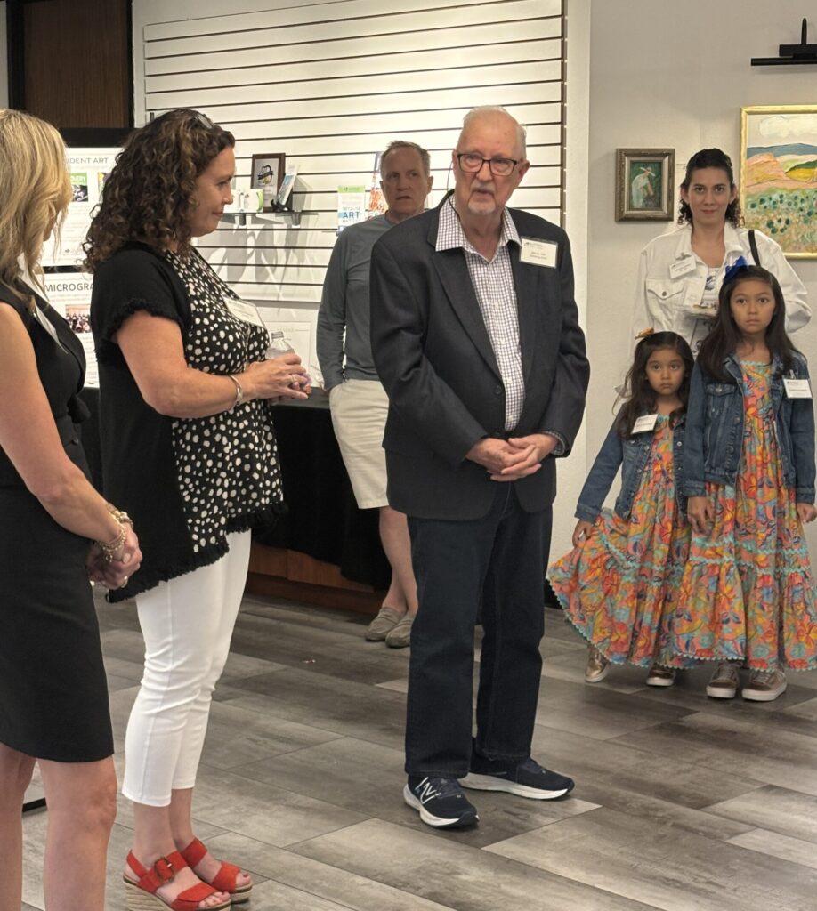 Curator Annette Palmer introduces Jim N. Hill at the opening of his solo exhibition at The Woodlands Arts Council on June 5, 2025. (Photo by Laura Landsbaum)