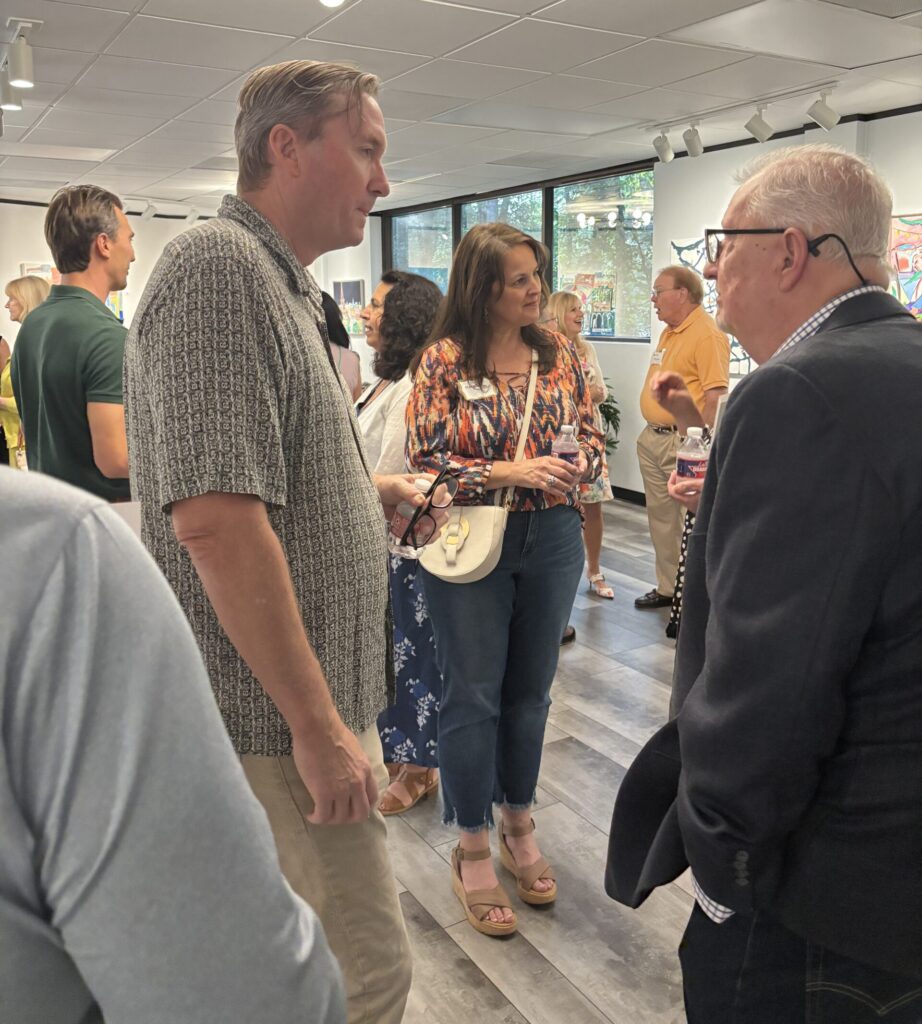 Guests visit with Jim N. Hill at the opening of his exhibition on June 5, 2025, at The Woodlands Arts Council’s gallery space. (Photo by Laura Landsbaum)