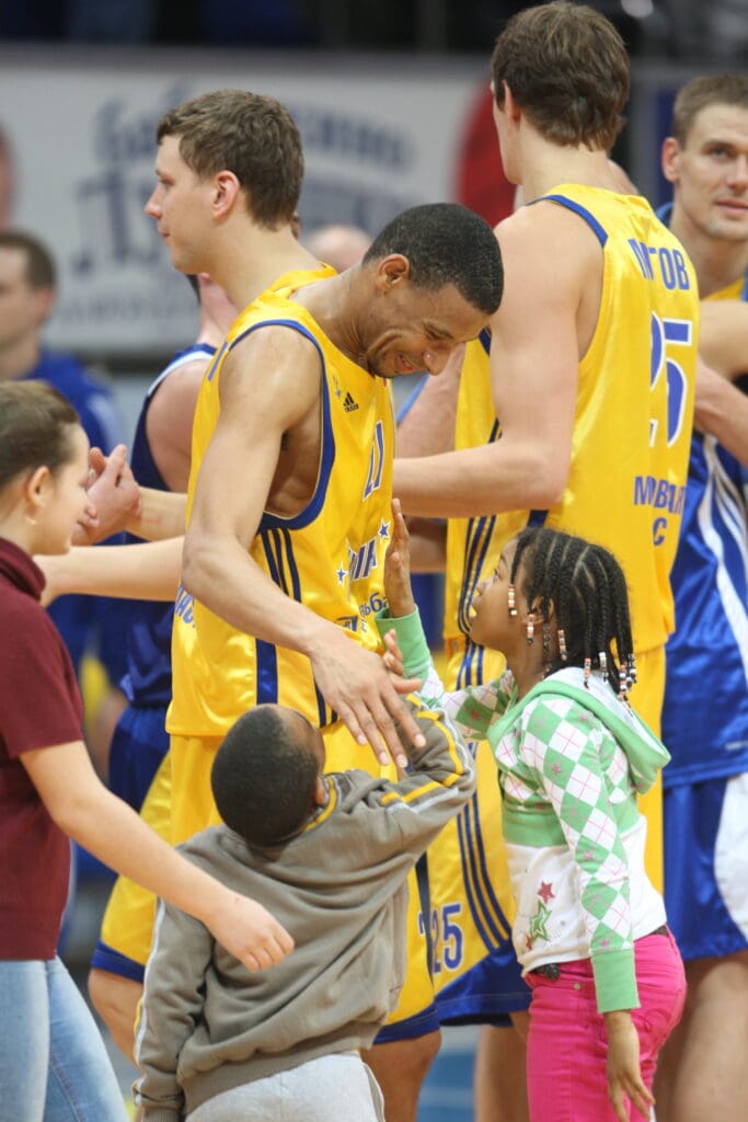 Kelly McCarty shares a moment with his kids — Chase McCarty and Eboni McCarty — after a game in Russia.