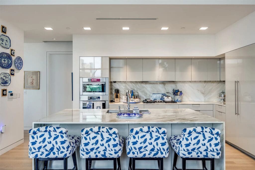 The kitchen is strictly business for the modern hostess, with custom lacquered cabinetry, marble appointments, Meile appliances, a wine tower, and abundant storage. (Photo by Compass RE Texas)