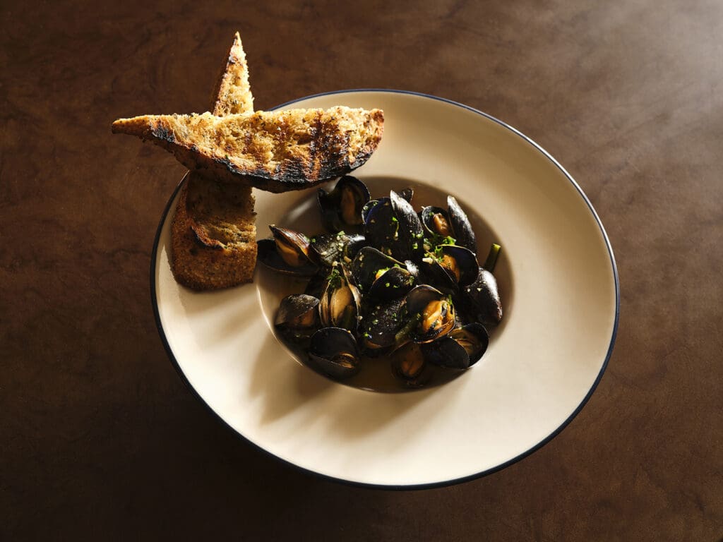 Caswell's Shiner Bock steamed mussels with rajas and garlic bread shine at Latuli. (Photo by Frank Frances)