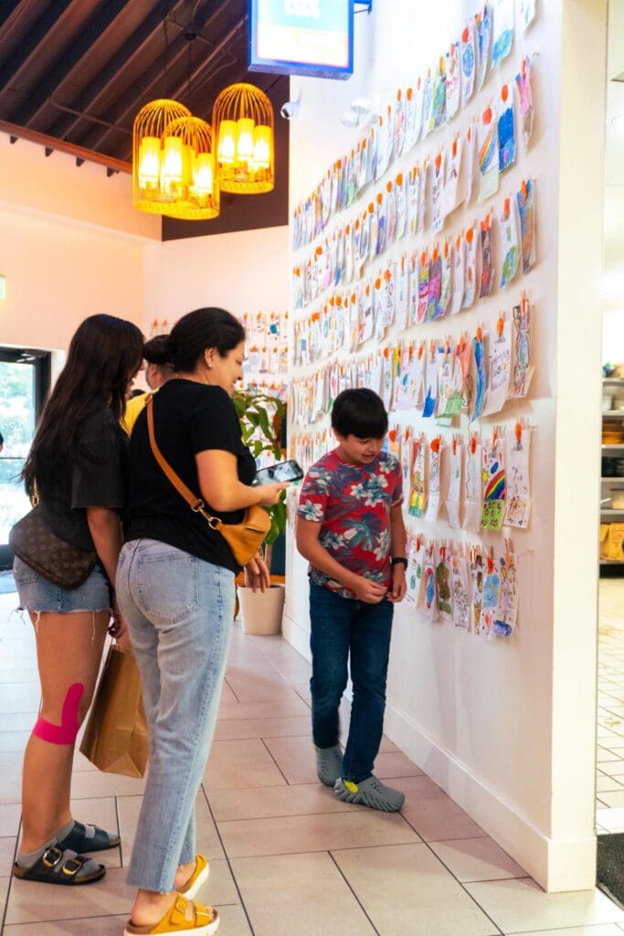 Guests admire student-designed Earth Day to-go bags on display at Phat Eatery in The Woodlands. (Photo courtesy Phat Eatery)