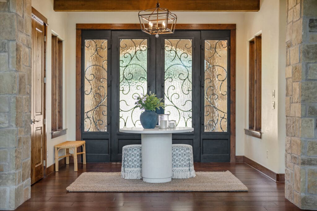 Wrought iron doors and natural materials set a warm, refined tone in the home’s inviting entryway. (Photo by The Ashton Agency)