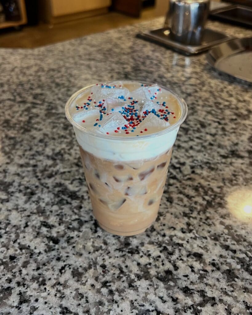 Good City offers festive iced lattes, like this recent patriotic variety topped with red, white, and blue sprinkles. (Photo courtesy of Good City)