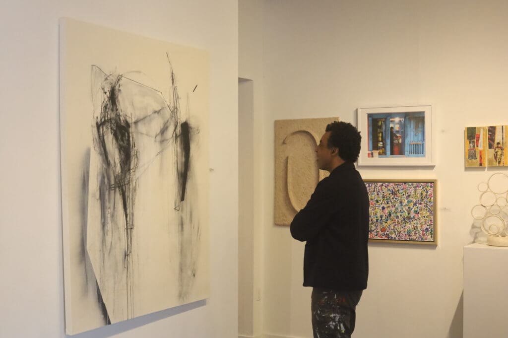 Artist Rick Lowe, co-founder and former executive director of Project Row Houses, views Lawrence Lange's acrylic, ink and charcoal on canvas work "A Once Proud and Noble Man" at Archway Gallery. Lowe juried Archway's 17th Annual Juried Exhibition  recently. (Courtesy Archway Gallery, Houston)