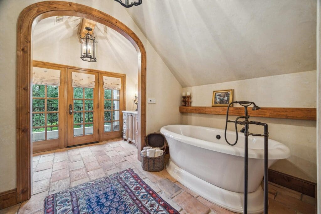 The primary bath at 3 E Rivercrest Drive has a gas fireplace across from the tub