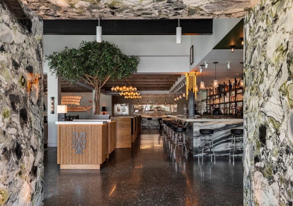 Inside the renovated space is anchored by a mighty olive tree–the national tree of Greece–while its walls are lined with art created by Greek artists. Photo by Claudia Casbarian.