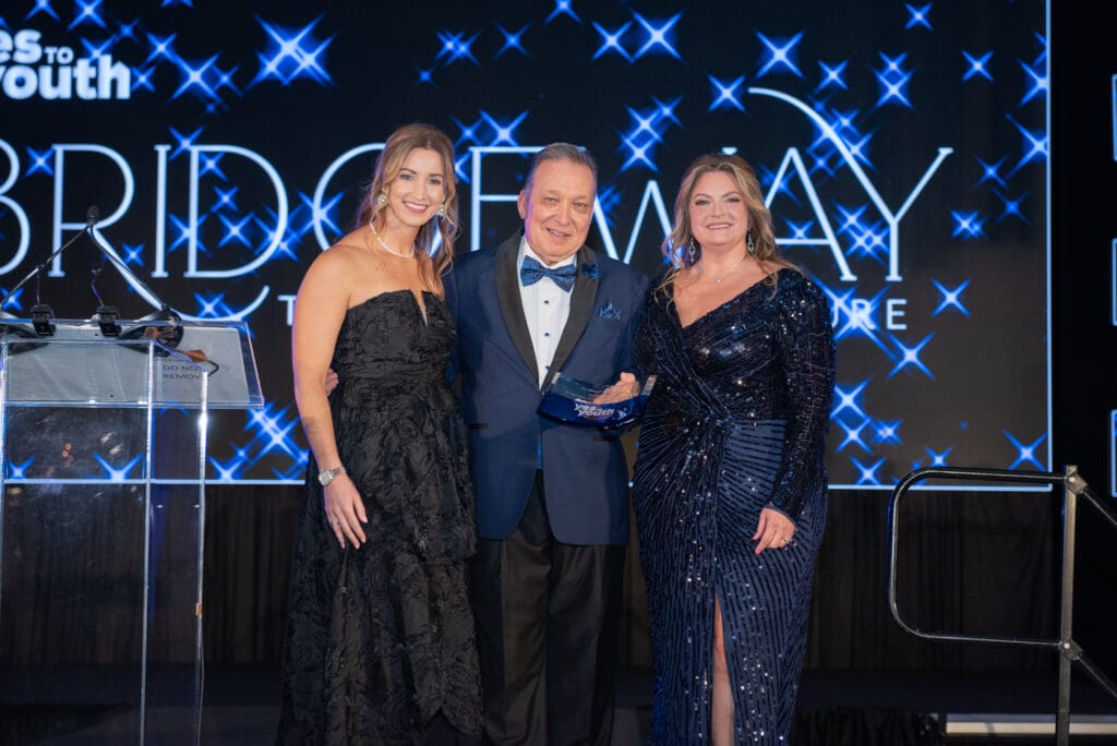 Lauren Janssen (left) and Michele Kooken (right) with honoree William D. Malone Jr. at YES to YOUTH’s Bridgeway to a Brighter Future gala.