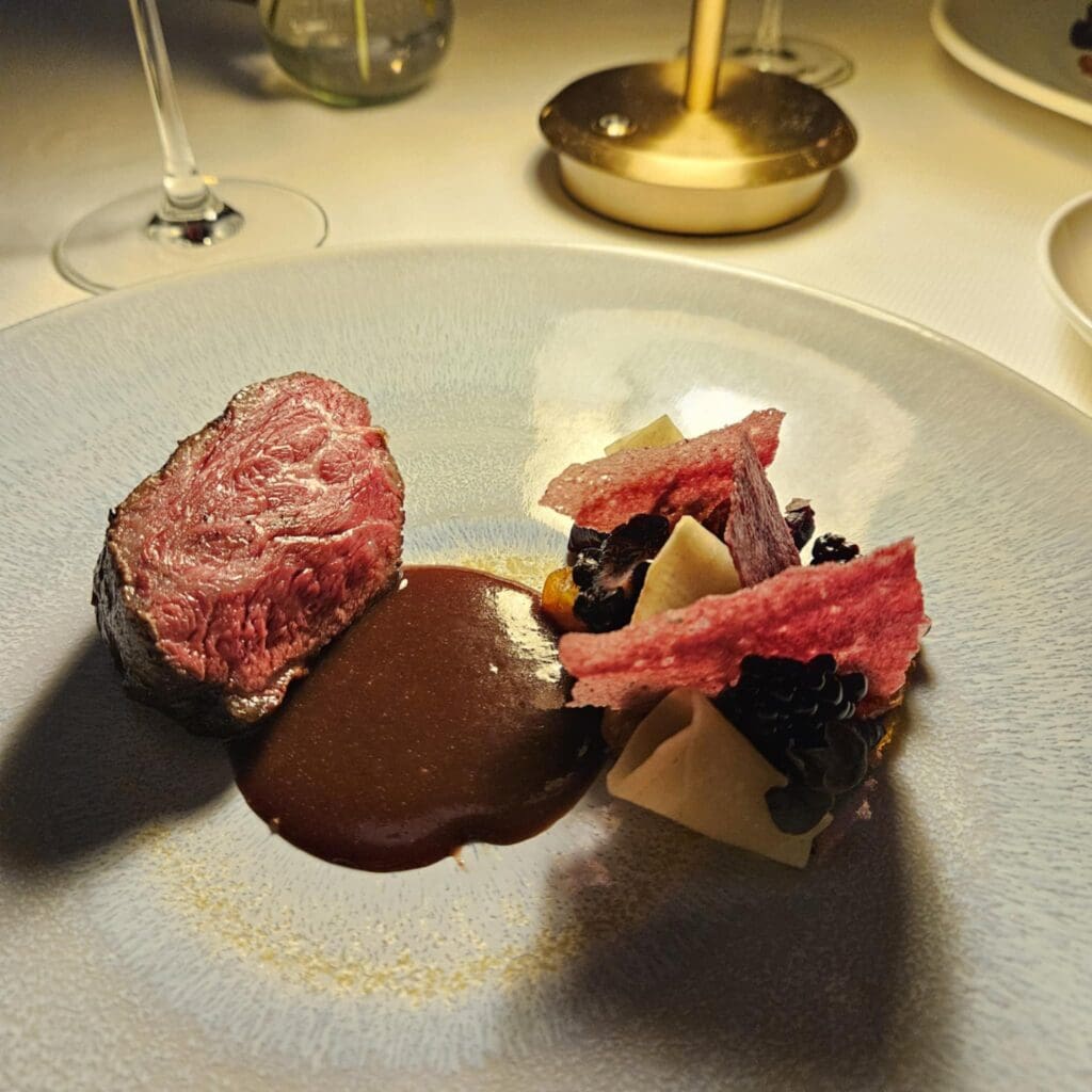 At The Crescent Hotel’s Blue Room, Wagyu Picanha was served with black garlic sauce and balanced richness with beet panna cotta and fresh blackberries. (Photo by Edward Brown)
