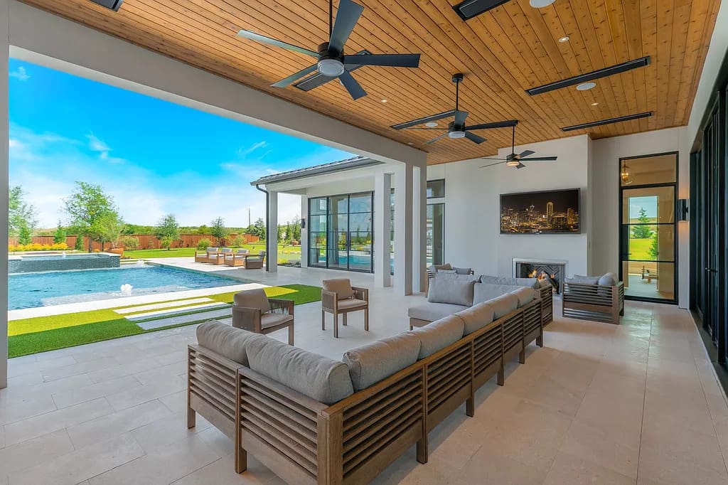 A dramatic entryway with marble floors and black paneled walls frames views of the pool and lawn. (Courtesy)