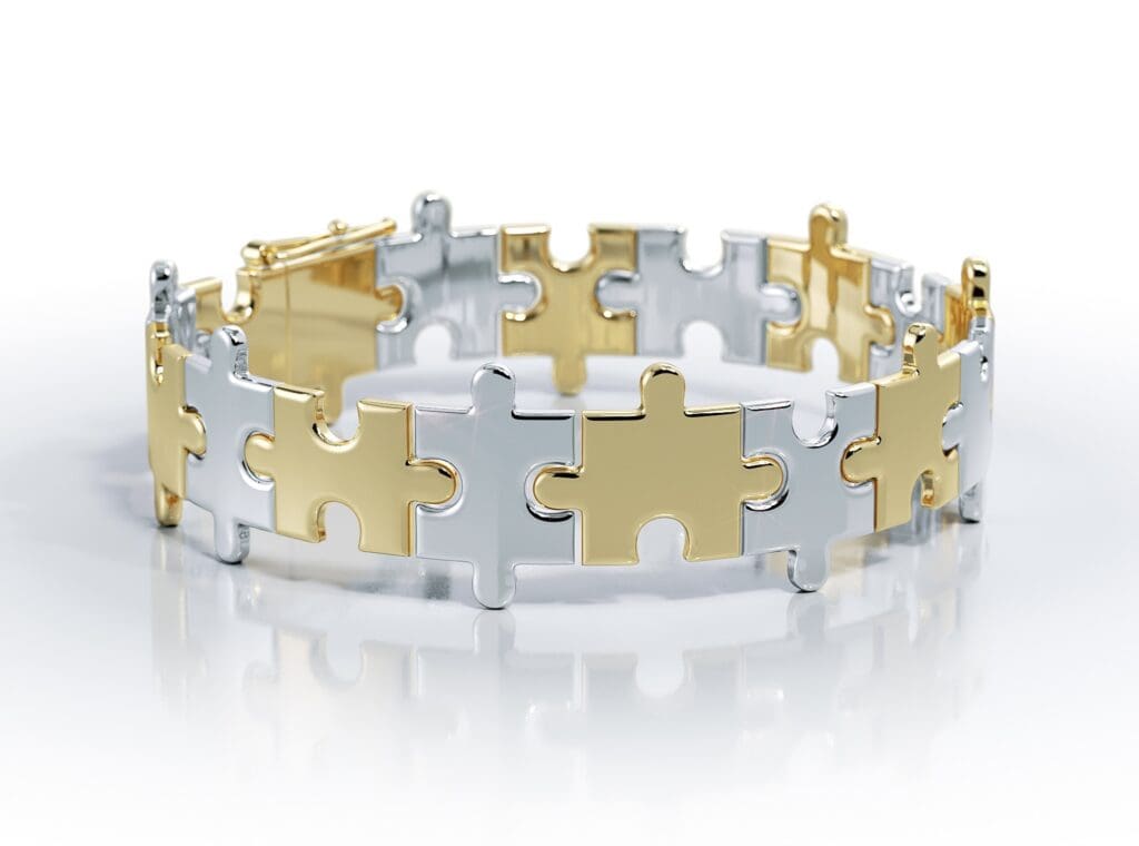 Valobra Master Jeweler's custom Love Is a Puzzle bracelet is shown here in white and yellow gold, can be designed with various embellishments including fancy stones and diamonds.
