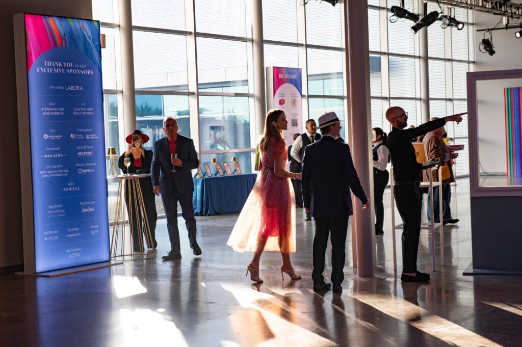 Upon arrival at the Design District warehouse where the event is held, attendees mill about the room, cocktails in hand, admiring the gallery of works and discovering new artists. (Photo by Tamytha Cameron )