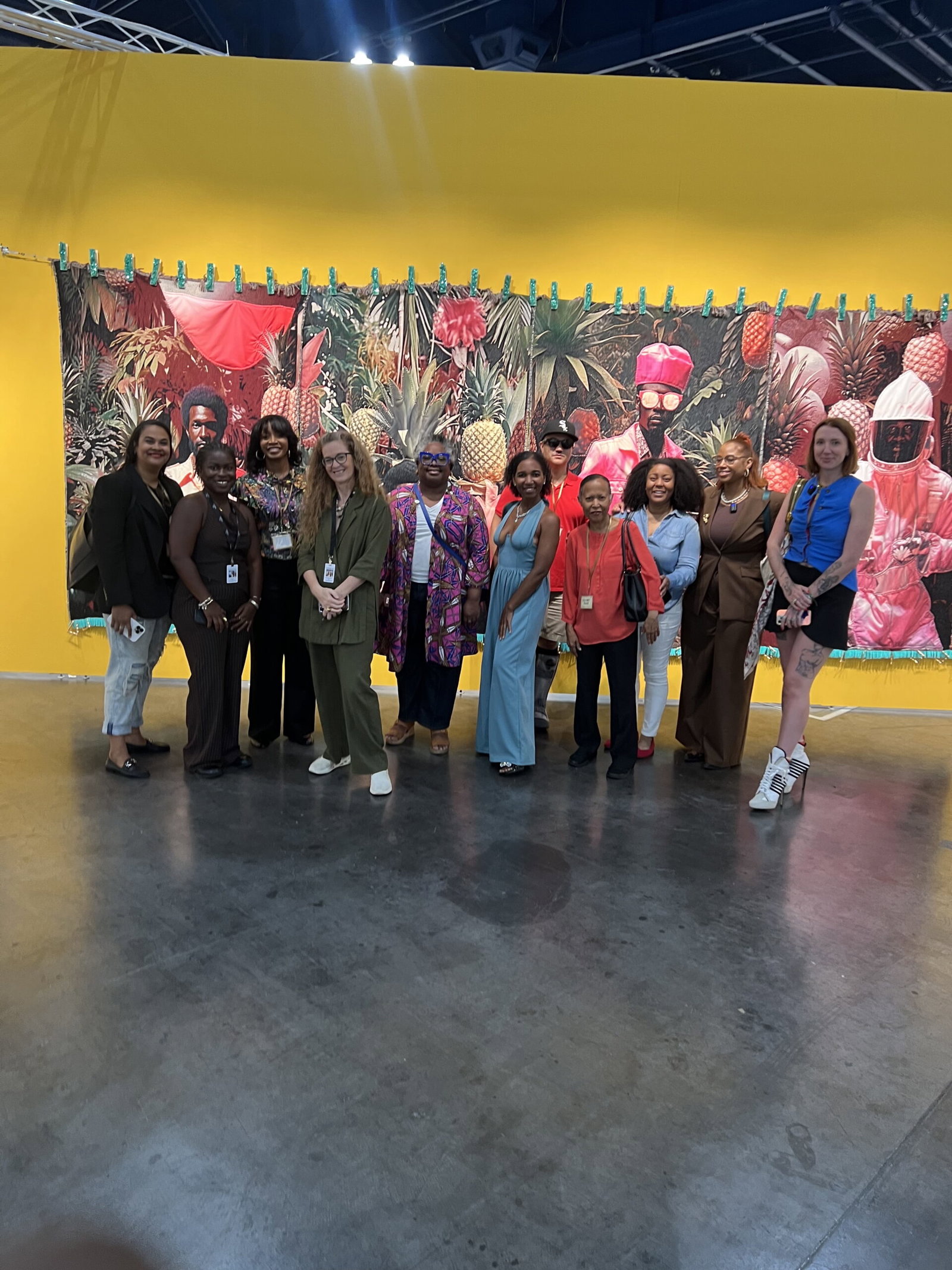 GloryLand led by Moriah Alise, second from right, with her art group leads a tour of Untitled Art, Houston, 2025 Shown here, in Tern Gallery's booth with a heroic work by April Bey.