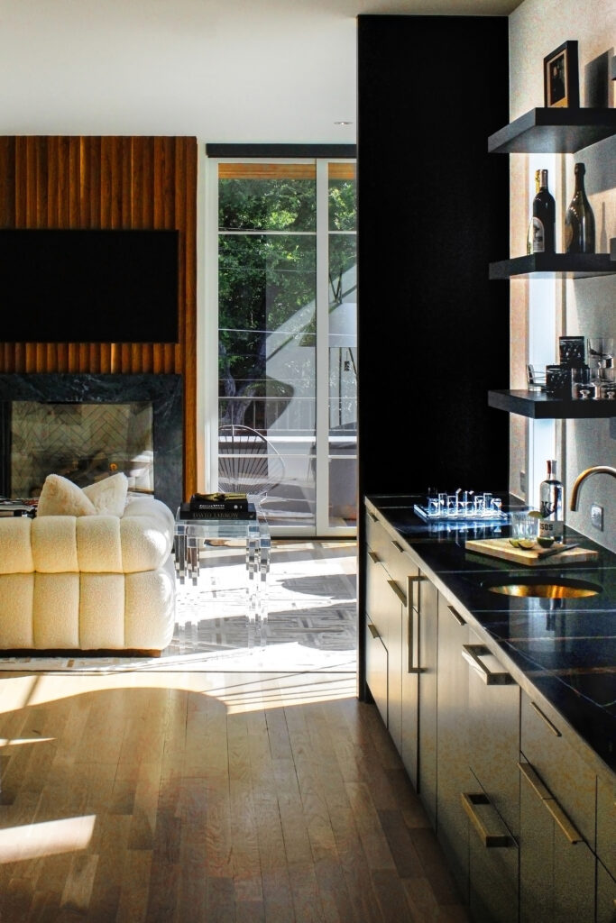 The second floor of Springbrook Street features an open-concept living space with a sculptural fireplace and a showpiece bar. (Photo by Matthew Tomlanovich)