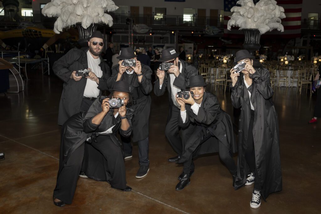 "Papparazzi" ushered guests downstairs to the ballroom that dazzled in black, white, and gold. (Photo by Thomas Garza)