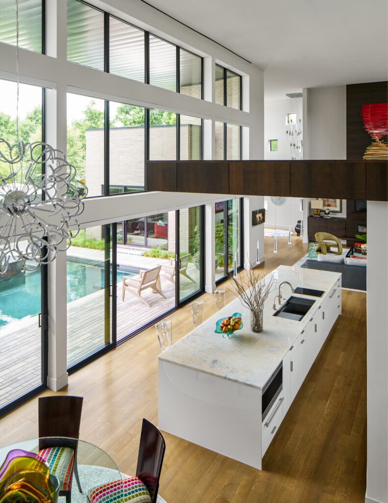 At Vanguard Way, A cantilevered kitchen ceiling floats above a 16-foot island, and floor-to-ceiling fireplaces showcase a locally-made glass sculpture. (Photo by Nathan Schroder)