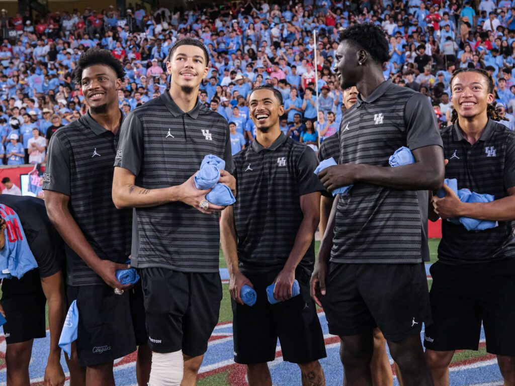 University of Houston basketball players Cedric Lath, Jacob McFarland, Milos Uzan, Kalifa Sakho and Kingston Flemings enjoy their moment on the field at a football game. (Photo by F. Carter Smith)