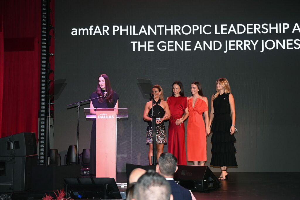 Jessica Jones (far L) accepts amfAR's Philanthropic Leadership Award onstage during amfAR Dallas Gala at Private Residence on October 04, 2025 in Dallas, Texas.  (Photo by Ryan Emberley)