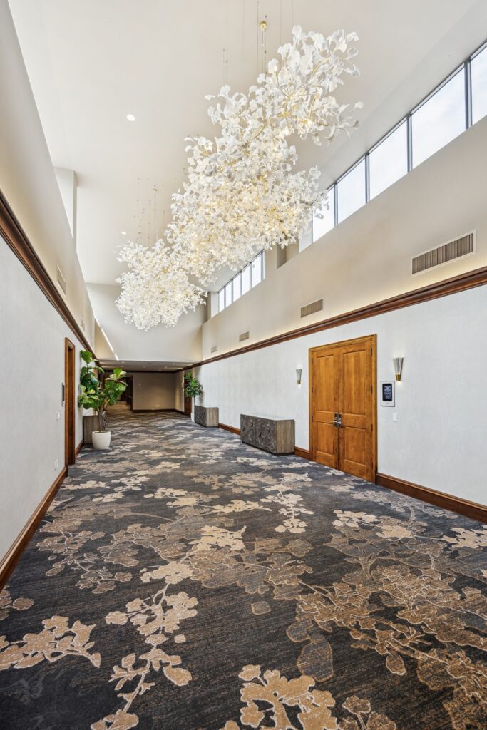 On the upper level of the Conference Center, a custom-designed, 35-foot statement Ginkgo branch chandelier floats down the middle of the corridor, just outside the Aspen Ballroom. (Photo by TK Images)