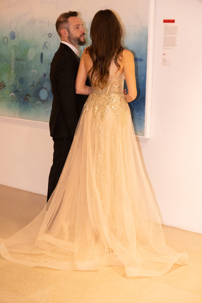 Guests admiring the artwork for auction.  (Photo by George Fiala)