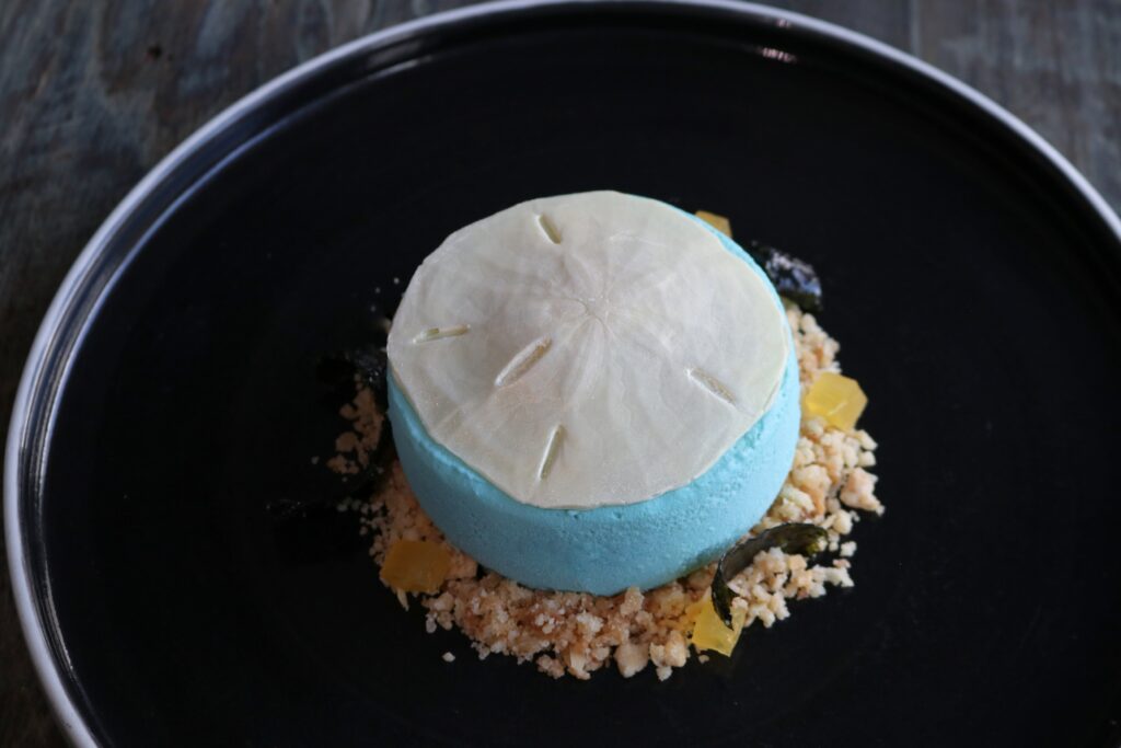 Dessert is where Ruben Ortega shines. He head-huddled with lead pastry chef Roxy Puga to create sweets such as Dólar de Arena, a white chocolate sand dollar poised atop a creamy coconut mousse with almond praline and candied strips of nori ($16). (Photo by Paula Murphy)