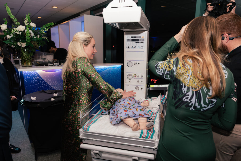 Dr. Adare Robinson practices pediatric CPR on a simulation doll at one of the innovation stations (Photo by Jay Simon)